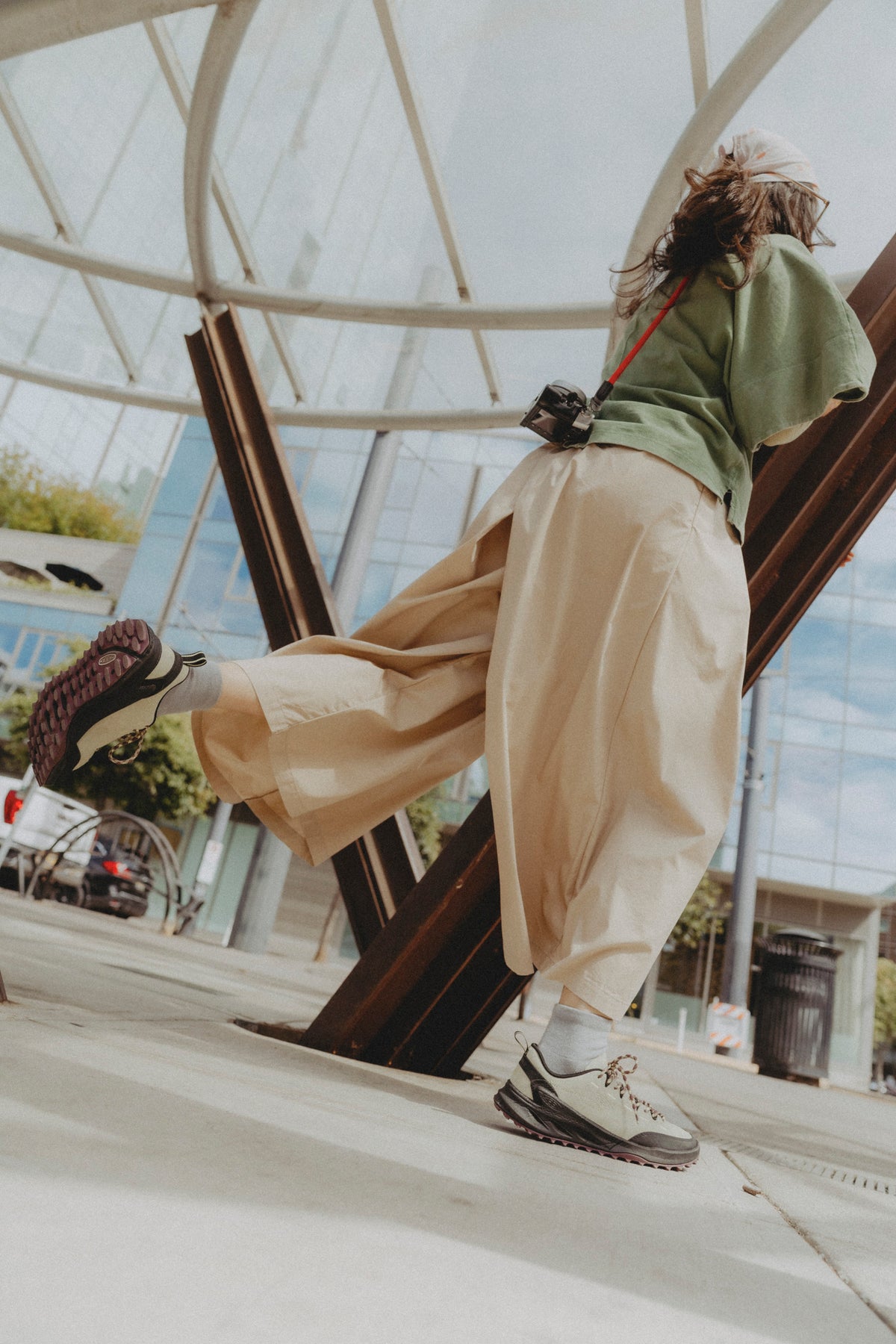 a woman stood wearing white balloon pants and keen jasper zionic trainers in beige with pink laces