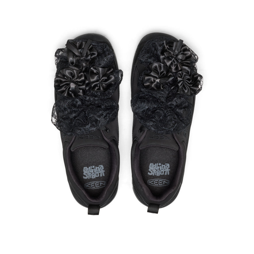 Black trainers  with floral decorations on a white background