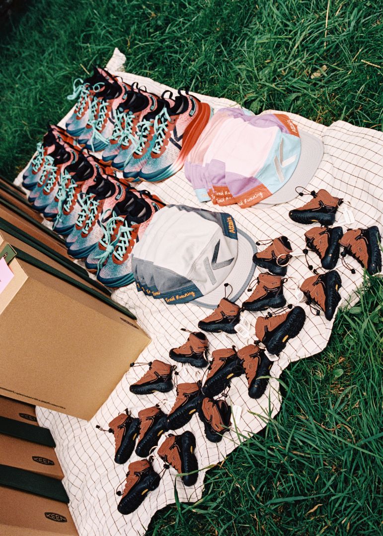 Keen seek trail running shoes arranged on a sheet with hats and Targhee IV keychains. 