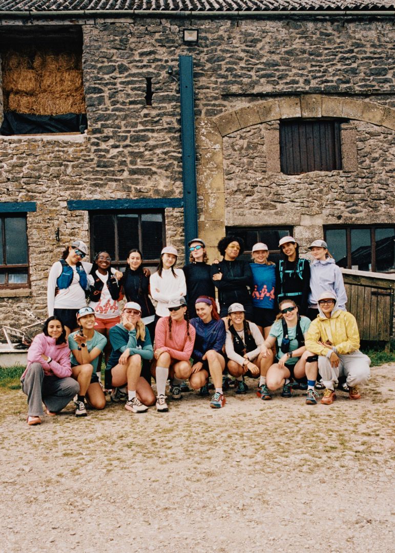 Group of people posing in front of a stone building