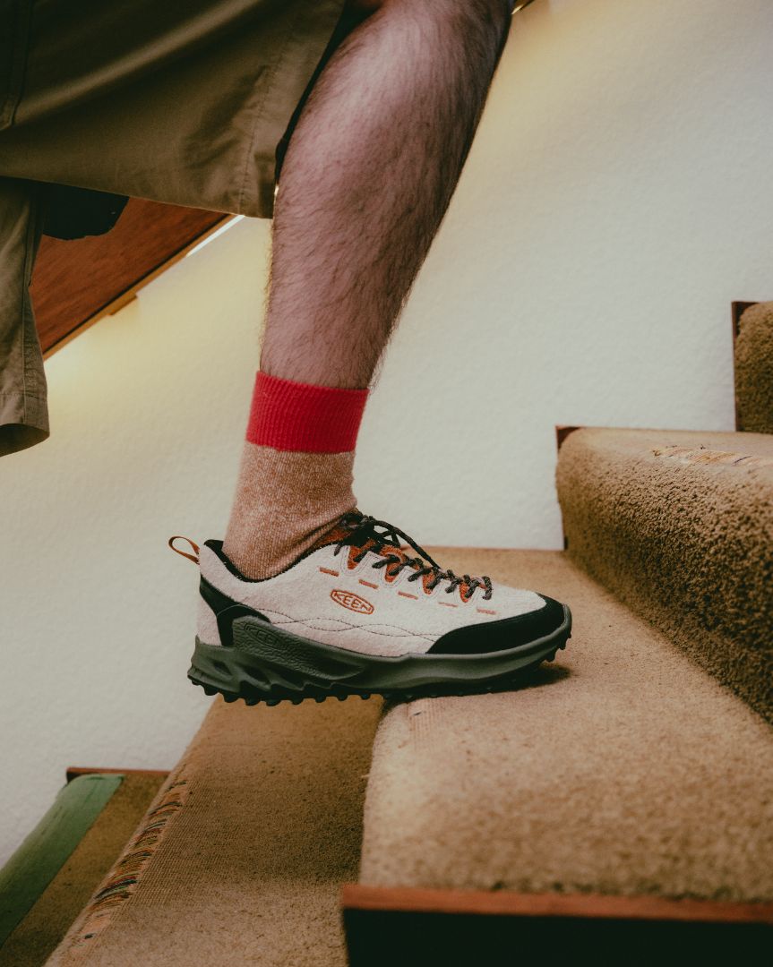 Person wearing a red sock and Keen Zionic Sneakers in a beige colour