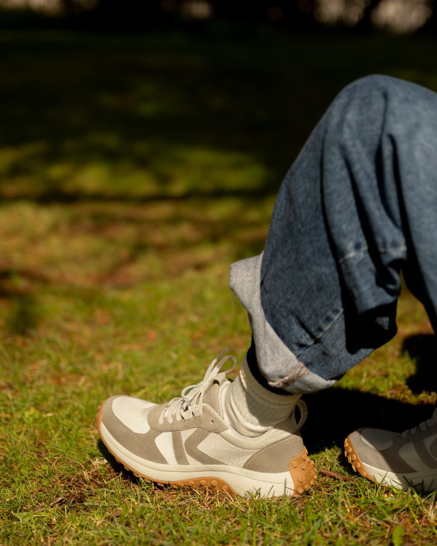 A person wearing the keen ks86 sneakers with jeans in a grassy environment.