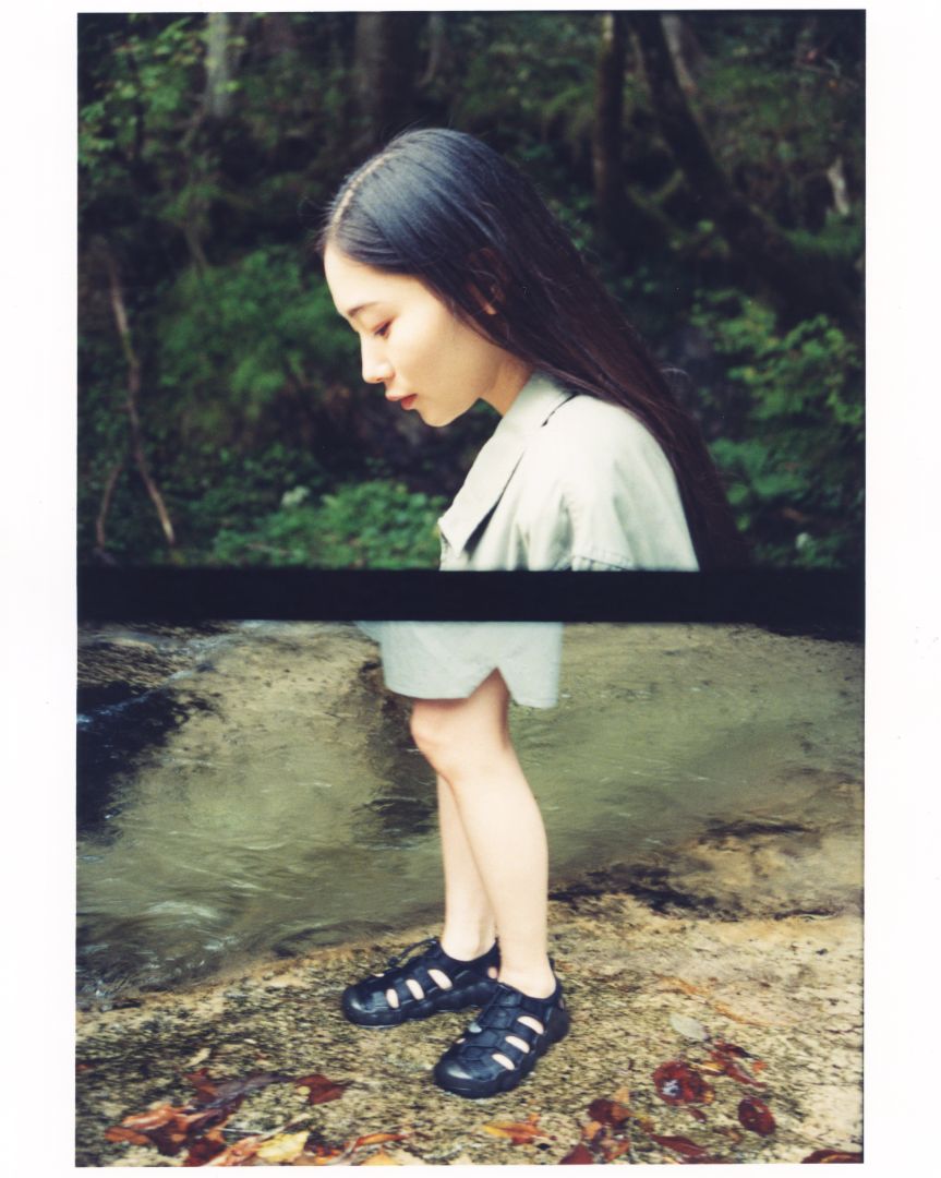 Person wearing black keen x snow peak collab hyperport closed‑toe sandals standing beside a shallow forest stream, shown in a stylised split‑frame photograph.