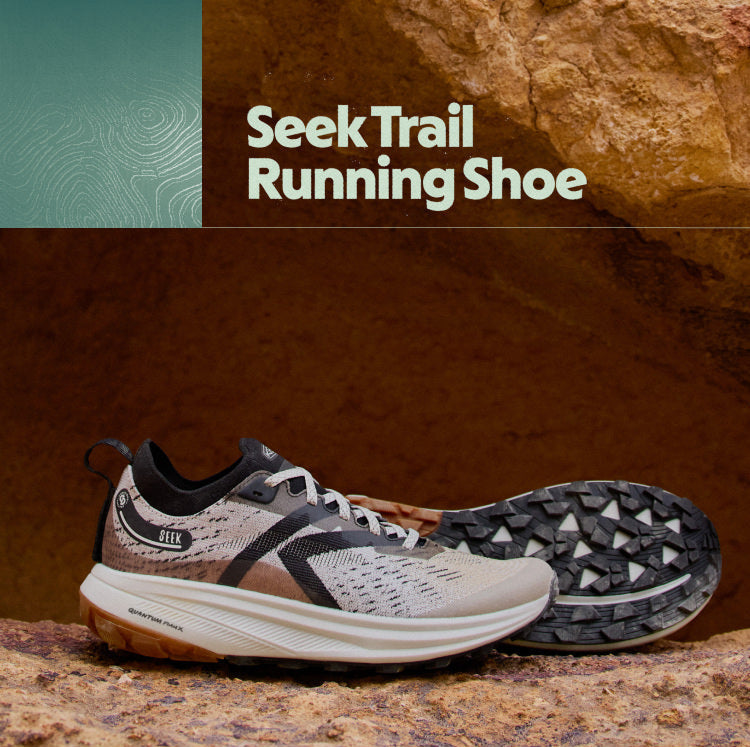 Trail running shoe with desert landscape and hikers in the background