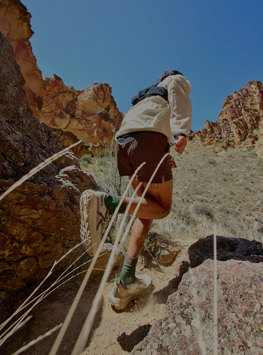 Person hiking on a rocky trail with desert landscape