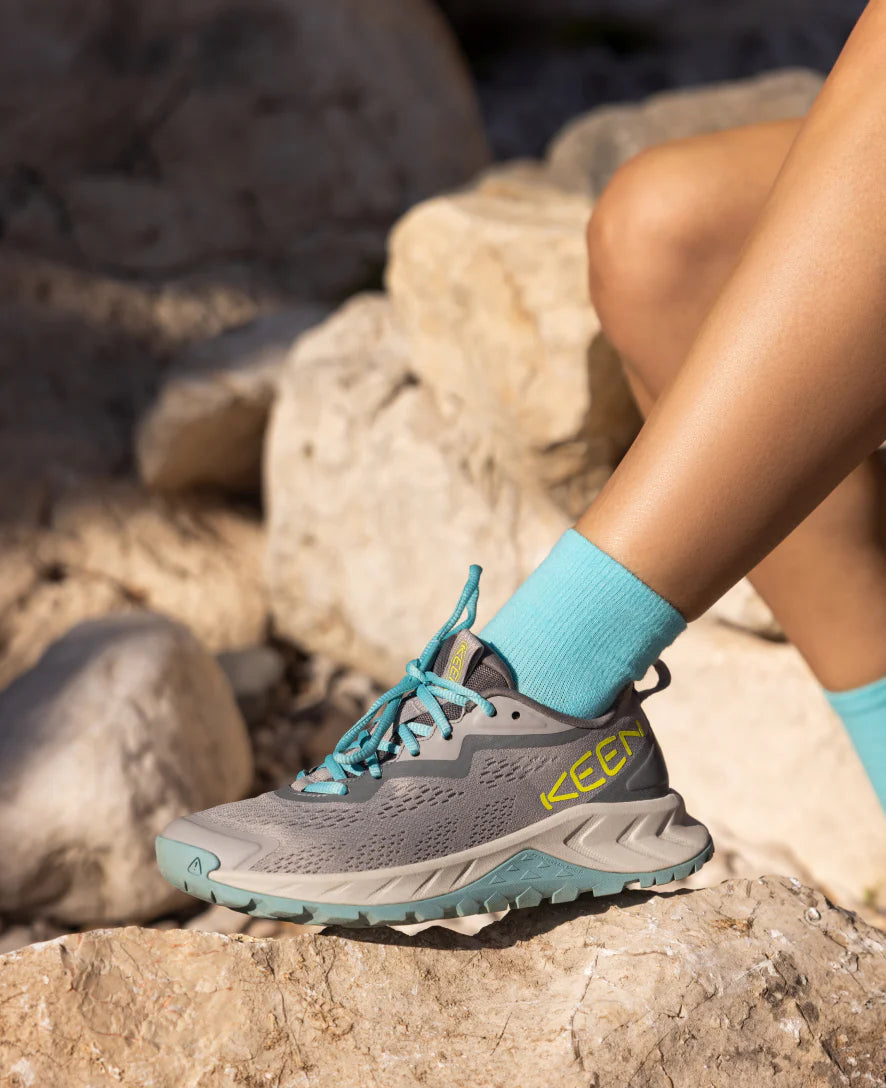 The women's versacore speed shoe posed in a rocky environment.