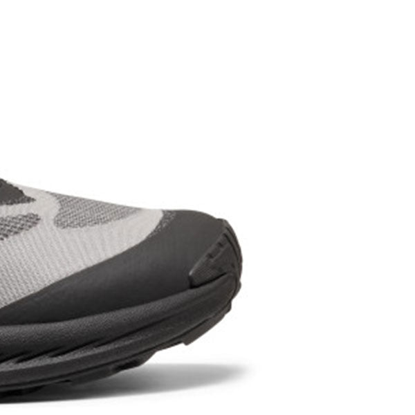 Close-up of the toe area of a gray and black athletic shoe on a white background.