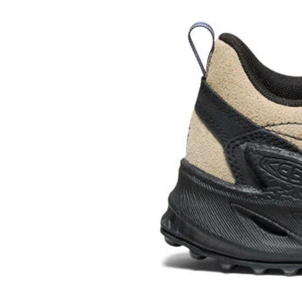 Close-up side view of a Keen shoe showing the heel and midsole, with a beige suede-like side panel, black synthetic overlays, and a black sole on a white background.