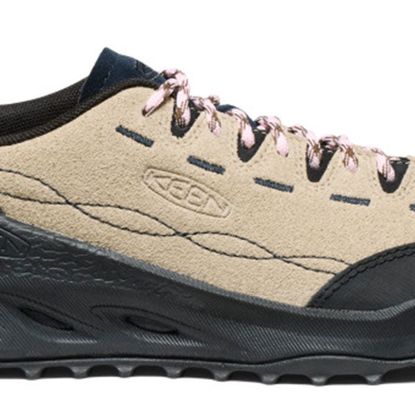 A close-up of a Keen hiking shoe in beige suede and black synthetic materials, featuring metallic rose gold laces and a black sole.