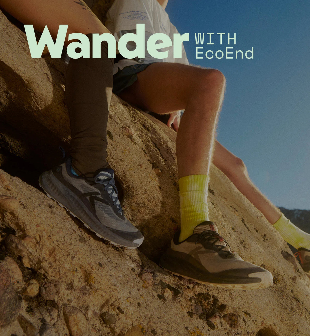 Two people sitting on a rocky outdoor surface,wearing trail running shoes with bright yellow socks