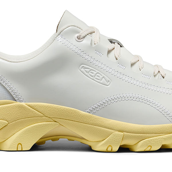 Close-up of the midsection of the White Phileo x Keen collab shoe with a yellow sole on a white background